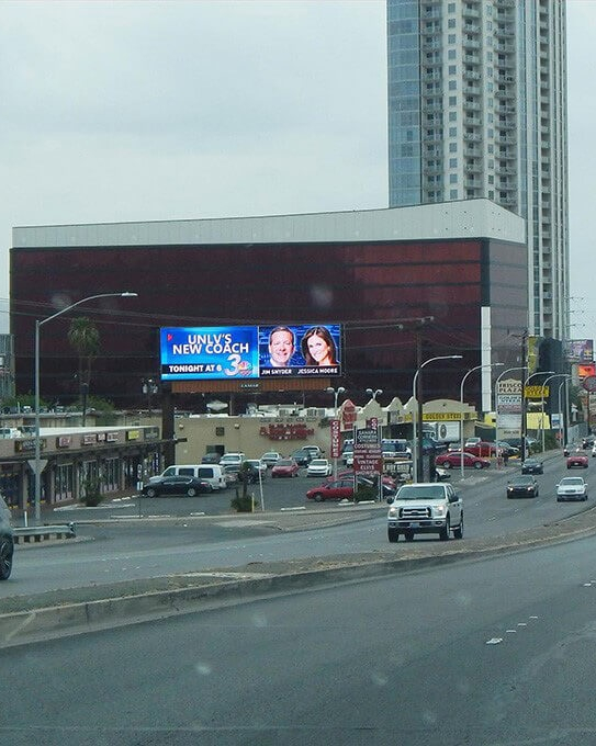 channel-3-billboard Digital billboard announcing UNLV’s new coach on a busy street, promoting an evening segment on Channel 3.